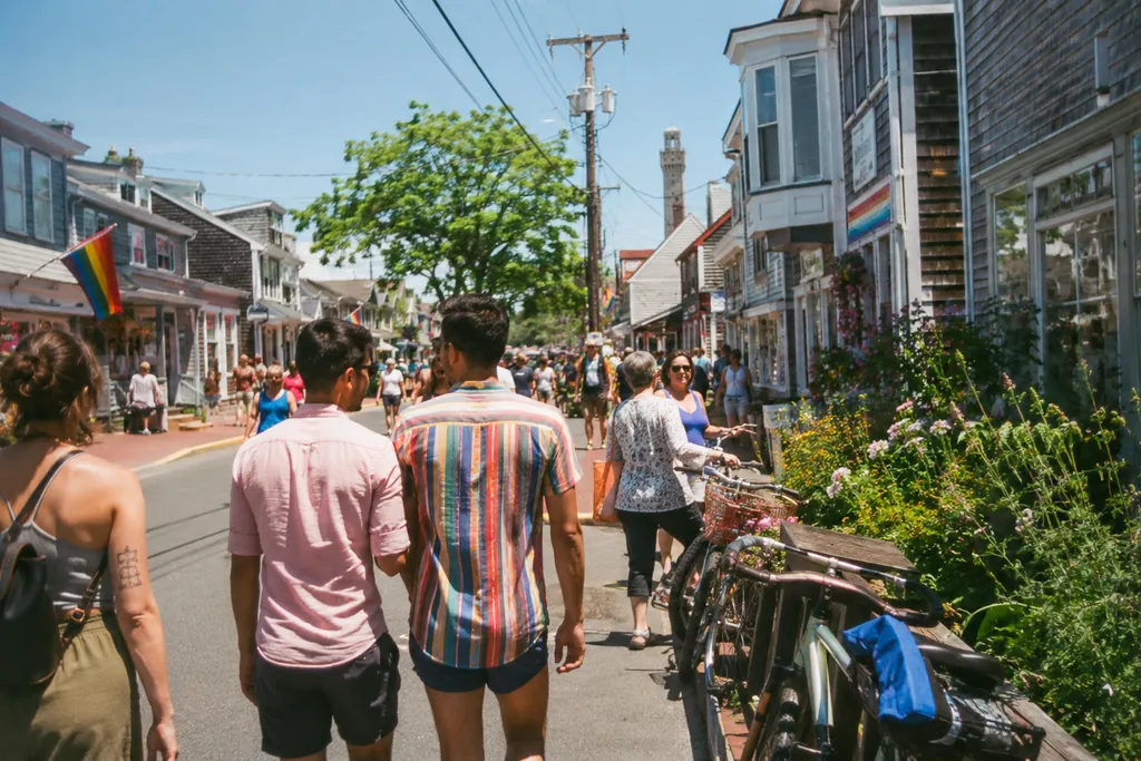 People stroll down a street lined with shops and bicycles.
